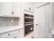Sleek, stainless steel double ovens are built in with white cabinets and stylish backsplash at 2028 Cedar Falls Dr # 10, Waxhaw, NC 28173