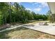 Backyard with a concrete patio, lush green trees, and natural landscaping at 2046 E Park Dr, Lancaster, SC 29720