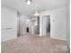 Bright hallway with neutral carpeting offering access to multiple rooms and an attic at 2046 E Park Dr, Lancaster, SC 29720