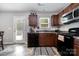 Well-lit kitchen featuring stainless steel appliances, dark wood cabinets, and tile flooring at 2046 E Park Dr, Lancaster, SC 29720