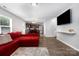 Open floorplan featuring hardwood floors, TV, red sectional sofa, and dining area with a view into the kitchen at 2046 E Park Dr, Lancaster, SC 29720