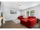 Comfortable living room featuring hardwood floors, a large window, and a red sectional sofa at 2046 E Park Dr, Lancaster, SC 29720