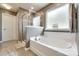 Bright bathroom with a soaking tub, frosted window, glass enclosed shower, and tiled floor at 3005 Oakmere Rd, Waxhaw, NC 28173