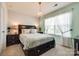 Charming bedroom with a dark wood bed frame, chandelier, and sheer curtains allowing natural light at 3005 Oakmere Rd, Waxhaw, NC 28173
