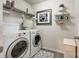 Well-lit laundry room featuring modern appliances, overhead shelving, and decorative accents at 3005 Oakmere Rd, Waxhaw, NC 28173
