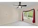 Bright bedroom featuring a ceiling fan and a large window with gray curtains at 3124 Arklow Rd, Charlotte, NC 28269