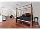 Open bedroom featuring hardwood floors, a four-poster bed, and natural light at 3124 Arklow Rd, Charlotte, NC 28269