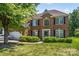 Lovely brick home featuring lush green landscaping, manicured lawn and a two-car garage at 3124 Arklow Rd, Charlotte, NC 28269