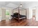 Main bedroom featuring hardwood floors, a four-poster bed, and natural light at 3124 Arklow Rd, Charlotte, NC 28269