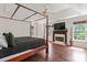 Spacious primary bedroom with hardwood floors, tray ceiling, four-poster bed, and fireplace at 3124 Arklow Rd, Charlotte, NC 28269
