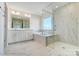 Modern bathroom featuring a glass-enclosed shower and soaking tub with marble-like tiling at 3242 Bozeman Ct # 8, Stanley, NC 28164