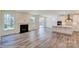 Bright living room showcasing a fireplace, luxury vinyl plank flooring, and access to the kitchen at 3242 Bozeman Ct # 8, Stanley, NC 28164