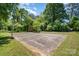 Exterior shot of a backyard basketball court with storage sheds and surrounding greenery at 3624 Delgany Dr, Charlotte, NC 28215
