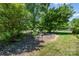 Backyard with a garden bench situated near the edge of wooded space at 3624 Delgany Dr, Charlotte, NC 28215