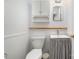 Neat bathroom featuring white wainscoting, a pedestal sink, and a well-maintained toilet at 3624 Delgany Dr, Charlotte, NC 28215