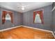 Spacious bedroom featuring hardwood floors, a ceiling fan, and natural light from large windows at 3624 Delgany Dr, Charlotte, NC 28215