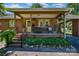 Charming brick home featuring a cozy covered front porch with inviting seating and hanging flower baskets at 3624 Delgany Dr, Charlotte, NC 28215