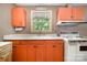 View of the retro kitchen featuring unique orange cabinets, bright countertops, and vintage appliances at 3624 Delgany Dr, Charlotte, NC 28215