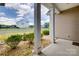 Covered back porch featuring views of the community, trimmed shrubs, lush green grass, and white support columns at 4211 Maggie Springs Way, Clover, SC 29710