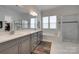 Luxurious bathroom featuring double vanity, soaking tub, and glass shower with marble-style tile at 4211 Maggie Springs Way, Clover, SC 29710