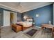 Stylish bedroom with blue accent wall, tray ceiling, wood floors, and adjacent staircase access at 4211 Maggie Springs Way, Clover, SC 29710