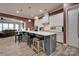Open kitchen with gray island, white cabinets, pendant lighting, stainless appliances, tile backsplash, and wood flooring at 4211 Maggie Springs Way, Clover, SC 29710