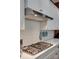 Close-up of a modern gas cooktop with stainless steel range hood and white subway tile backsplash at 4211 Maggie Springs Way, Clover, SC 29710