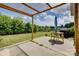 Outdoor patio with pergola, featuring a table, grill, and a beautiful view of the grassy backyard and surrounding trees at 4211 Maggie Springs Way, Clover, SC 29710