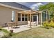 Covered patio adjoining sunroom, complete with an umbrella, table, and view of the lush lawn at 4211 Maggie Springs Way, Clover, SC 29710