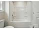 Bathroom featuring a white tub and shower combination with a door nearby at 4254 Black Ct # 231, Harrisburg, NC 28075
