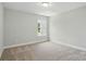 A simple bedroom with carpet, neutral paint, and a window at 4254 Black Ct # 231, Harrisburg, NC 28075