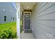 Inviting front entrance with gray door, stone accents, and manicured shrubbery at 4254 Black Ct # 231, Harrisburg, NC 28075