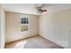 This bedroom features a ceiling fan and a window overlooking the backyard at 4408 Robins Nest Rd, Concord, NC 28027