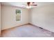 This bedroom has carpet floors, a ceiling fan, and a window overlooking the outdoors at 4408 Robins Nest Rd, Concord, NC 28027