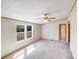 Carpeted living room featuring a ceiling fan, neutral walls, and backyard views at 4408 Robins Nest Rd, Concord, NC 28027