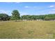 Spacious yard with scattered trees and neighboring houses, perfect for outdoor activities at 4408 Robins Nest Rd, Concord, NC 28027