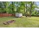 Fenced backyard featuring a storage shed and a fire pit at 6412 Old Meadow Rd # 69, Charlotte, NC 28227