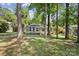 Single-story home surrounded by mature trees and a lush green lawn at 6412 Old Meadow Rd # 69, Charlotte, NC 28227