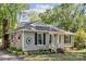 Charming single-story home featuring gray siding, black shutters, an American flag, and manicured landscaping at 6412 Old Meadow Rd # 69, Charlotte, NC 28227