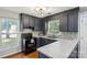 Modern kitchen with dark cabinetry, light countertops, mosaic tile backsplash, and stainless steel appliances at 6412 Old Meadow Rd # 69, Charlotte, NC 28227