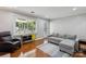 Comfortable living room with large window, hardwood floors, and neutral-toned furniture at 6412 Old Meadow Rd # 69, Charlotte, NC 28227