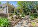 Scenic backyard with a screened porch, wood bench, stone pathway, and lush landscaping at 6914 Riesman Ln # 95, Charlotte, NC 28210