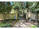 A private backyard gate is nestled among lush trees and gardens at 6914 Riesman Ln # 95, Charlotte, NC 28210