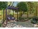 Relaxing backyard swing on a stone patio surrounded by beautiful landscaping and trees at 6914 Riesman Ln # 95, Charlotte, NC 28210