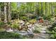 Backyard rock waterfall surrounded by lush landscaping and greenery at 6914 Riesman Ln # 95, Charlotte, NC 28210