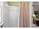 Bright bathroom featuring a shower-tub combo with decorative tile accents and charming floral patterned wallpaper at 6914 Riesman Ln # 95, Charlotte, NC 28210