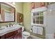 Charming bathroom with bright green walls, a floral valance, framed art, and a wooden vanity at 6914 Riesman Ln # 95, Charlotte, NC 28210