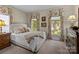 Inviting bedroom featuring floral curtains, neutral walls, plush carpeting, and a comfortable queen bed at 6914 Riesman Ln # 95, Charlotte, NC 28210