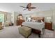 Spacious main bedroom with a leaf ceiling fan, wooden furniture, and carpeted floors at 6914 Riesman Ln # 95, Charlotte, NC 28210