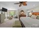 Bright main bedroom with a ceiling fan, furniture, and large windows at 6914 Riesman Ln # 95, Charlotte, NC 28210